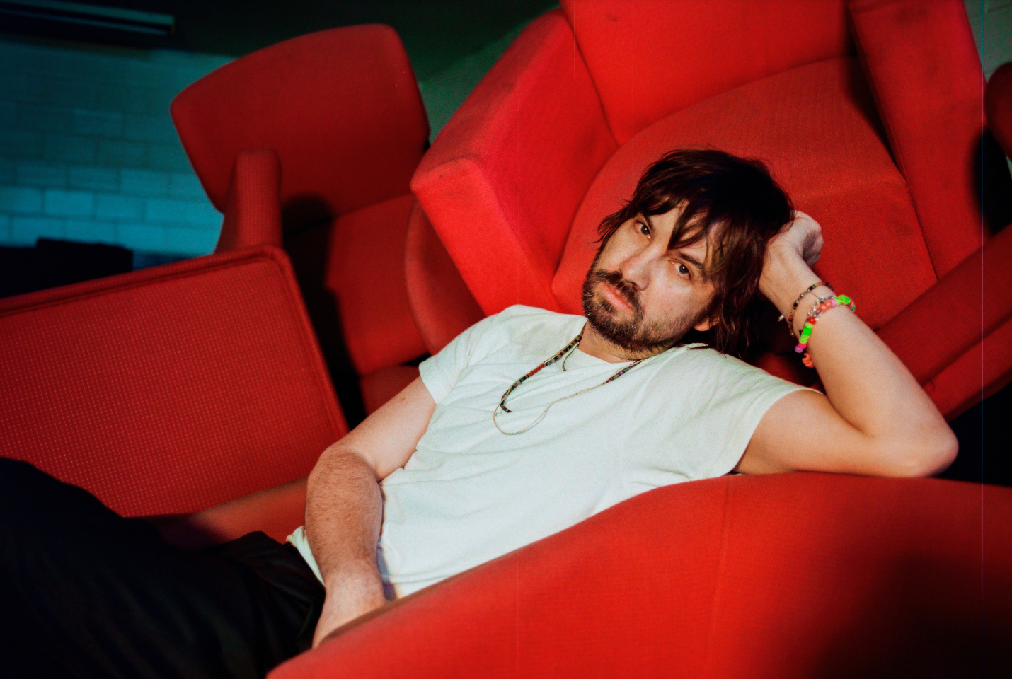 Artist Tame Impala on a red chair